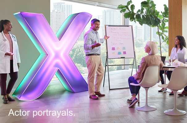 Healthcare professional with people giving a presentation and XCOPRI branded X