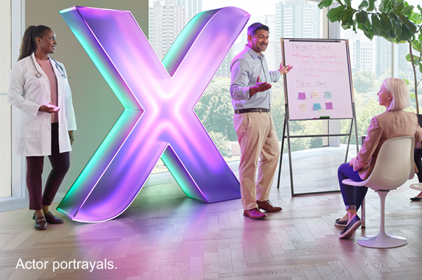 Healthcare professional with people giving a presentation and XCOPRI branded X